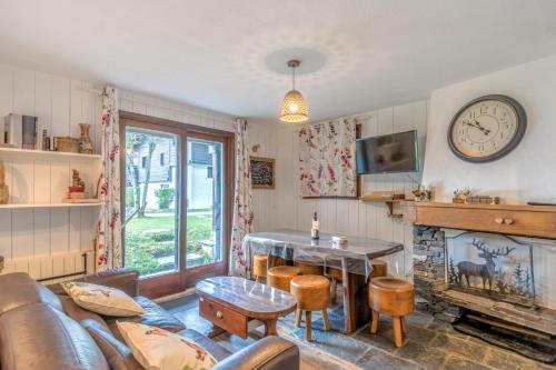 - un salon avec un canapé, une table et un réveil dans l'établissement Appartement Sous-Bois - Welkeys, à Chamonix-Mont-Blanc