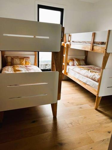 two bunk beds in a room with wooden floors at Beach House in Inverloch
