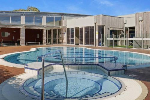 a large swimming pool in front of a building at Beach House in Inverloch