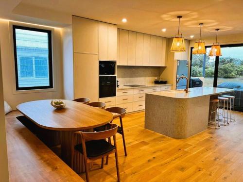 a kitchen with a wooden table and a kitchen island at Beach House in Inverloch