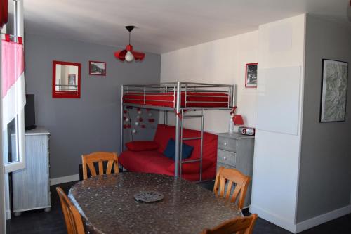 - une salle à manger avec une table et des lits superposés dans l'établissement Le Nid du Sancy - 5P - Proche station de ski, à Le Mont-Dore
