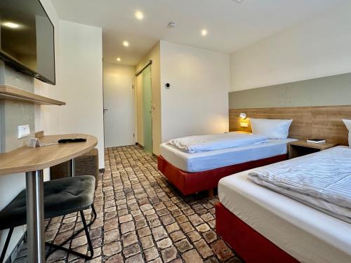 um quarto de hotel com duas camas e uma secretária em Gasthof Krancher em Rüdesheim am Rhein