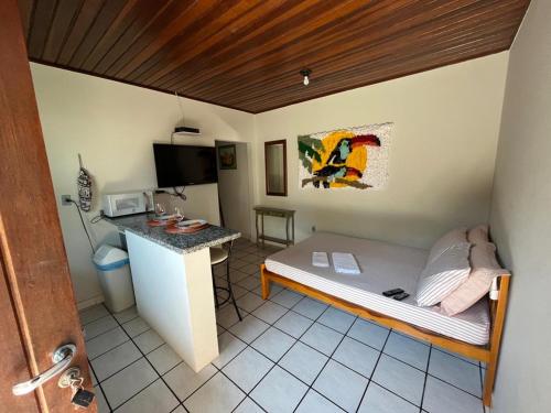 a small room with a bed and a desk at Loft Canarinho - Praia do Campeche in Florianópolis