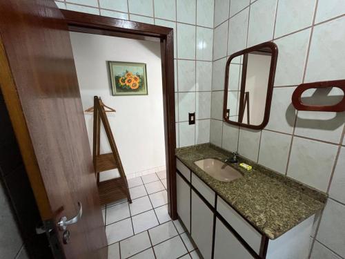 uma casa de banho com um lavatório e um espelho em Loft Canarinho - Praia do Campeche em Florianópolis
