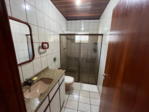a bathroom with a shower and a sink and a toilet at Loft Canarinho - Praia do Campeche in Florianópolis