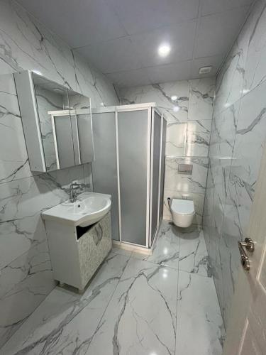 a white bathroom with a sink and a toilet at 6 şubat apartmanı in Avanos