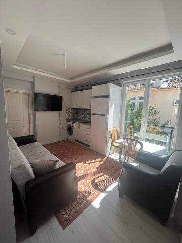ein Wohnzimmer mit einem Sofa und einer Küche in der Unterkunft 6 şubat apartmanı in Avanos