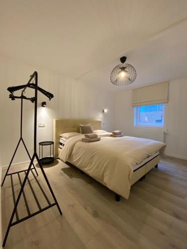 Un dormitorio con una cama grande y un trípode en Les amies en Blankenberge