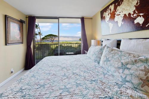 a bedroom with a large bed with a large window at Kihei's Seaside Siesta: Ocean View Lanai & Pool in Kihei
