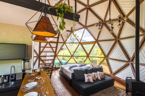 a living room with a bed and a large window at Freedome Domos e Chalés in São Francisco Xavier