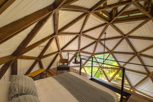 an attic room with a bed and a window at Freedome Domos e Chalés in São Francisco Xavier