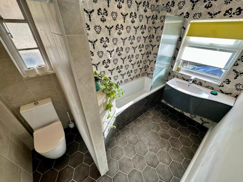 an overhead view of a bathroom with a toilet and a sink at Beautiful House in London - Abbey Wood in Abbey Wood