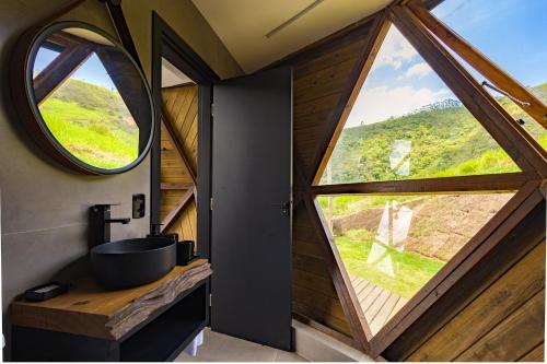 a bathroom with a sink and a large window at Freedome Domos e Chalés in São Francisco Xavier