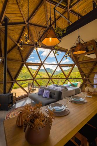 a living room with a couch and a large window at Freedome Domos e Chalés in São Francisco Xavier