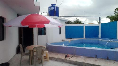 un tavolo e un ombrellone accanto alla piscina di Casa Tonsupa a Tonsupa