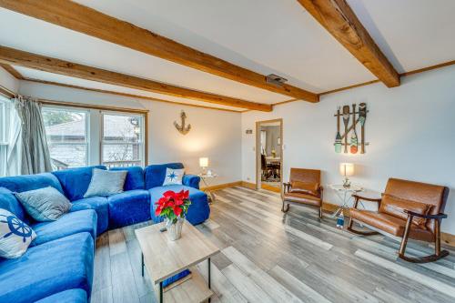 a living room with a blue couch and wooden floors at Waterfront Fox Lake Vacation Rental with Fire Pit! in Fox Lake
