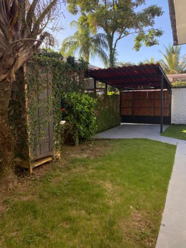 a garage with a fence and a gate and a grass yard at Casa Piscina in Santa Teresa Beach