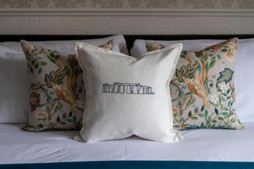 a white pillow with the word infinity on it on a bed at Fairlawn House in Amesbury