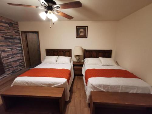 a bedroom with two beds and a ceiling fan at Hotel Casa Posos in Guanajuato