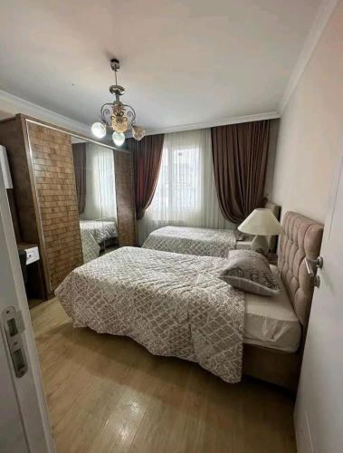 a bedroom with two beds and a chandelier at شقة انيقة مطلة على البحر in Istanbul