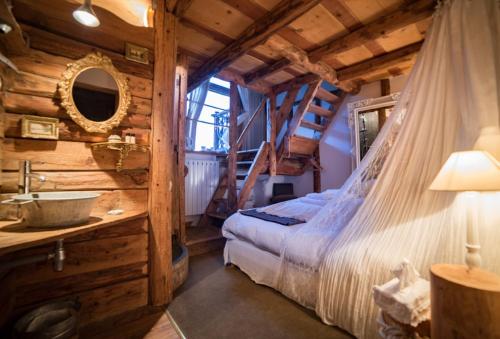 a bedroom in a log cabin with a bed and a sink at La Ferme d'Angele in Séez