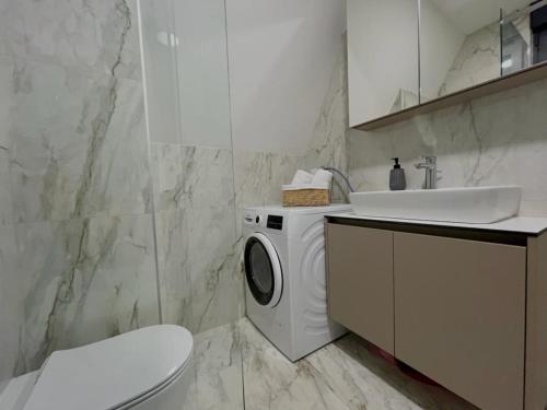 uma casa de banho com uma máquina de lavar roupa e um lavatório em Villa Anemar em Blidinje