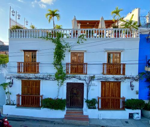 een wit gebouw met houten deuren en ramen bij Patio de Getsemani in Cartagena