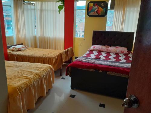 a hotel room with two beds and a bed sidx sidx sidx at Hospedaje errante andino in Puno