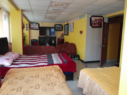 a room with two beds and a couch at Hospedaje errante andino in Puno