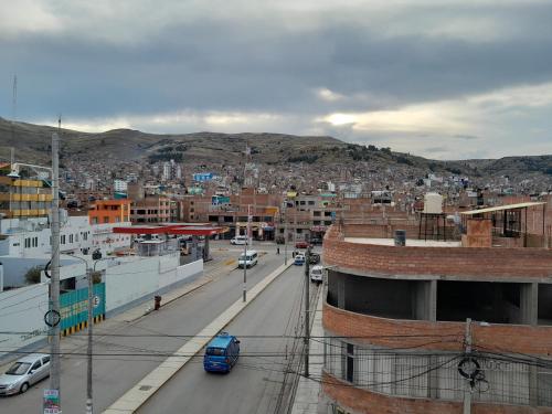 a city with cars driving down a street at Hospedaje errante andino in Puno