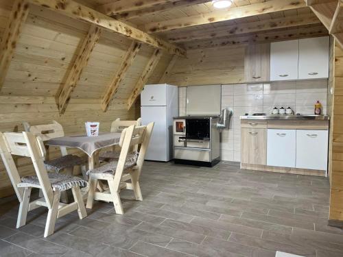 La cuisine est équipée d'une table, de chaises et d'un réfrigérateur. dans l'établissement Forest rest, à Plužine