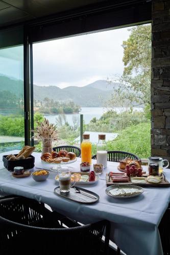 un tavolo con colazione e vista di Campos River House a Figueiró dos Vinhos