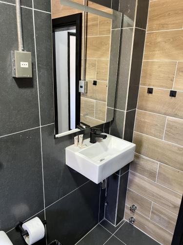 a bathroom with a white sink and a mirror at VOY Hostales - 4 Norte in Viña del Mar