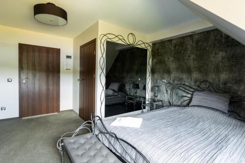 - une chambre avec un grand lit et un miroir dans l'établissement Hotel Magnat, à Suchedniów