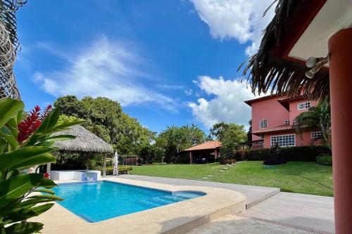 a swimming pool in front of a house at Relaxing family Beach House with Pool in Río Hato