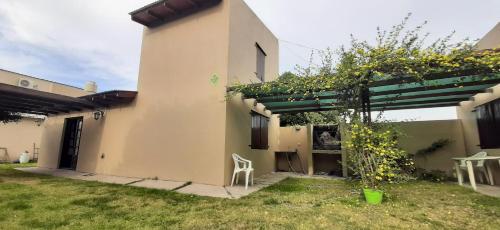 Una casa con una pérgola a un lado. en Lleku lafken en Balneario Claromecó