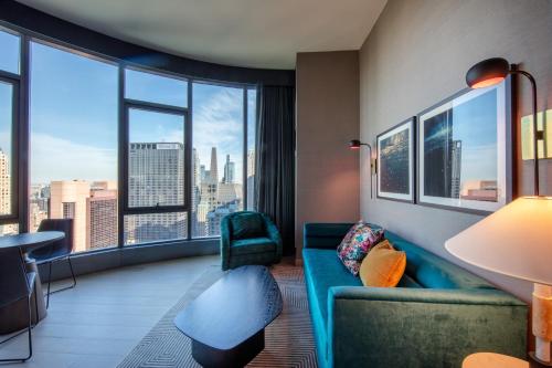 a living room with a couch and a large window at Tempo By Hilton New York Times Square in New York