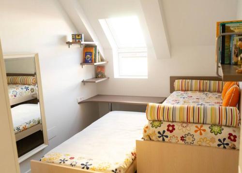 een kleine slaapkamer met een bed en een spiegel bij Apartamento NUEVO en el centro de León in León