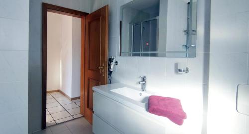 ein Badezimmer mit einem Waschbecken und einem rosa Handtuch darauf in der Unterkunft Moderne Maisonette mit Garten in Unterschleißheim
