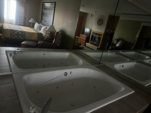 a large bath tub in a hotel room with a bed at Super 8 by Wyndham Sparta in Sparta