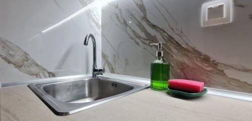 a sink with a green bottle sitting next to it at ΑΘΗΝΑ A7 in Katerini