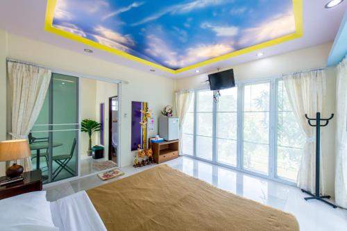 a bedroom with a bed and a tv on a ceiling at Poomvarin Resort in Ban Wang Takhrai