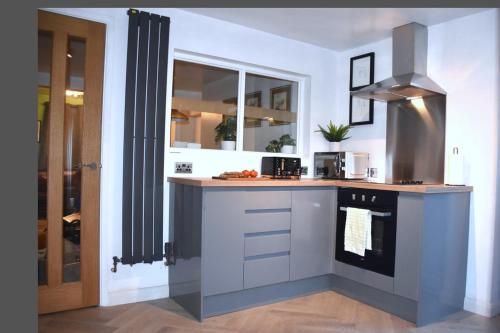 a kitchen with a counter with a stove top oven at Bard's Nest Scholars Cottage, Central Stratford, 5 mins walk to RSC in Stratford-upon-Avon