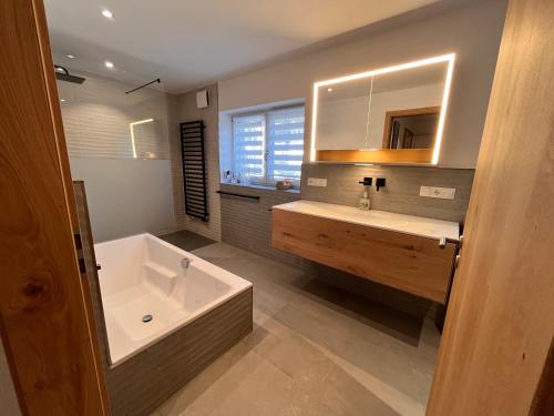 a bathroom with a tub and a sink and a bath tub at Ferienwohnung Trissl in Oberaudorf
