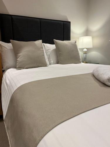 a large white bed with a black headboard and pillows at The Hillcrest, Luxury Accommodation in Castleblayney Town in Castleblayney