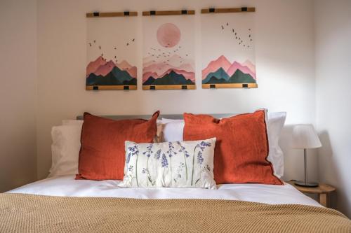 um quarto com uma cama com almofadas laranja em Milia House 2BR in Oxford Centre with free parking em Oxford