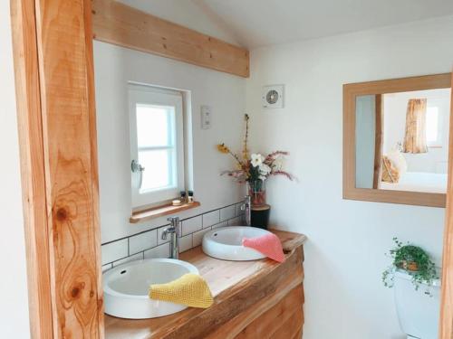 a bathroom with two sinks and a mirror at The Holford Arms in Tetbury