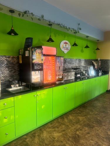 a kitchen with green cabinets and a green wall at Super 8 by Wyndham Sparta in Sparta