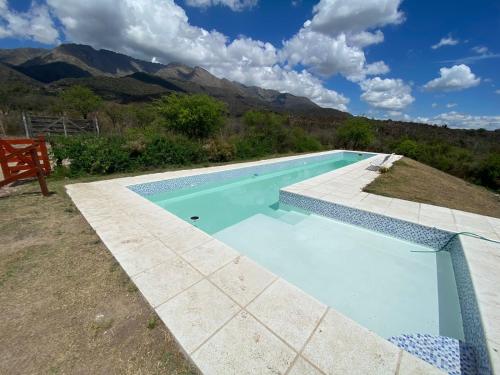 una piscina con banco y montañas de fondo en Yana Uwiha, Las Rabonas en Las Rabonas