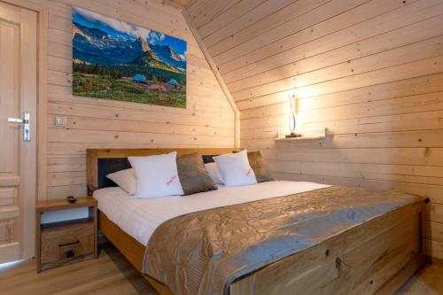 a bedroom with a bed in a wooden cabin at Leśny Dwór Premium Chalets Zakopane in Murzasichle